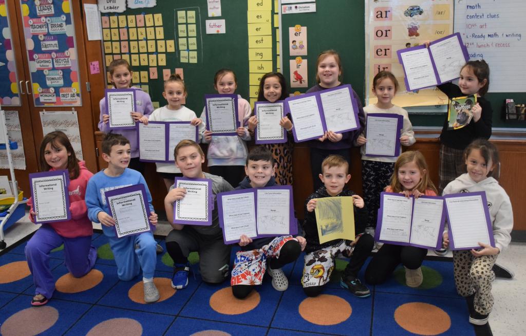 kids on carpet holding report papers